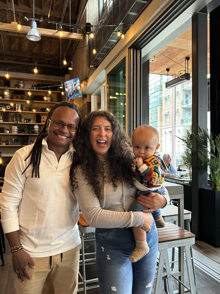 man and woman with baby boy all standing inside a restaurant